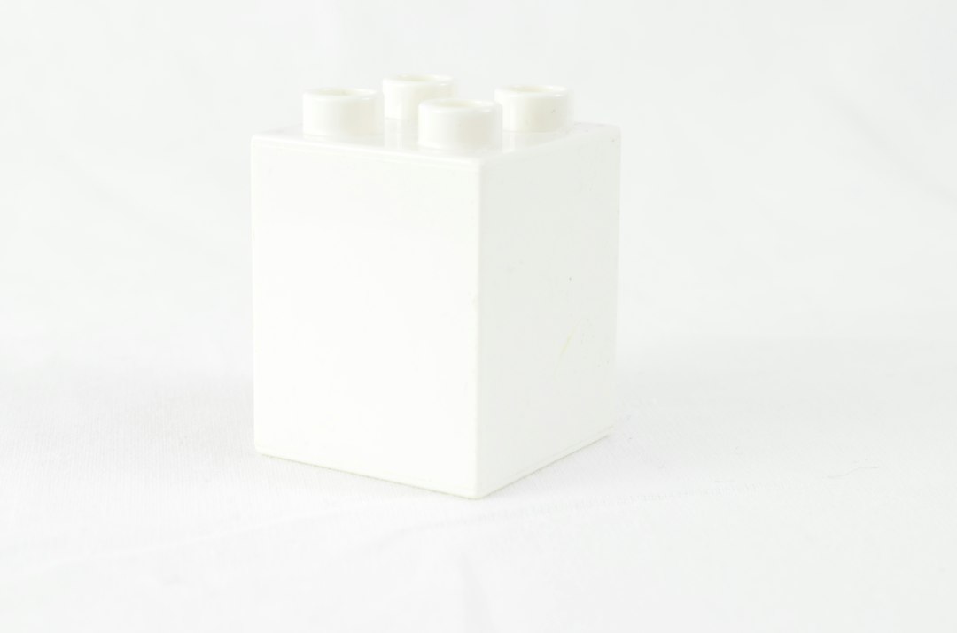 a white box with four white candles in it
