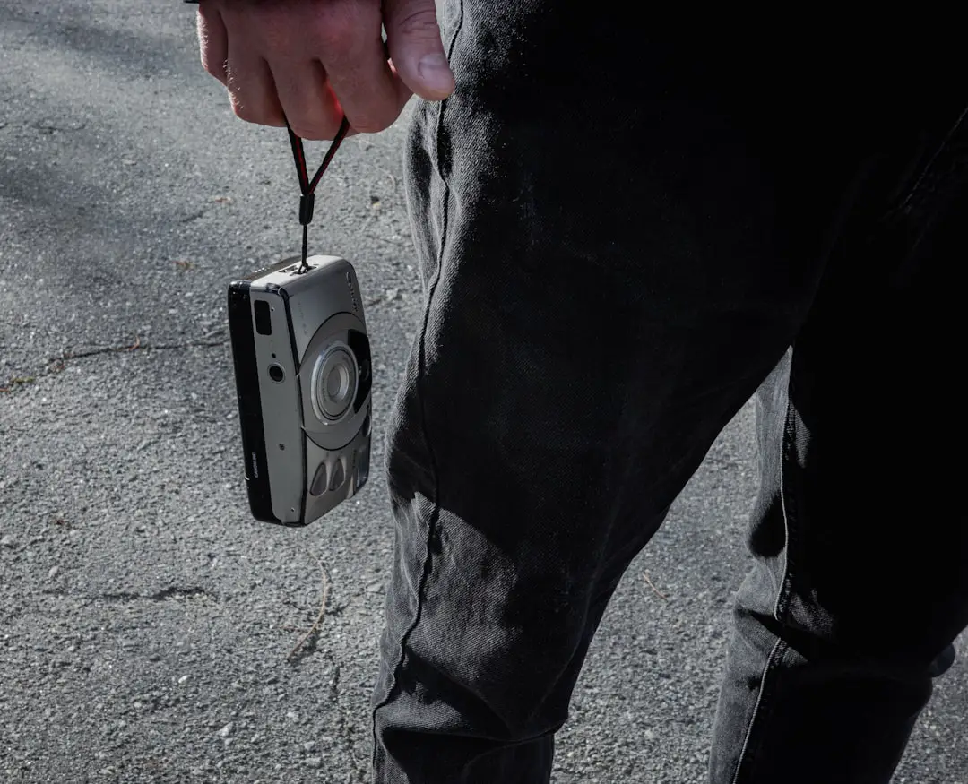 a person holding a camera attached to a cord